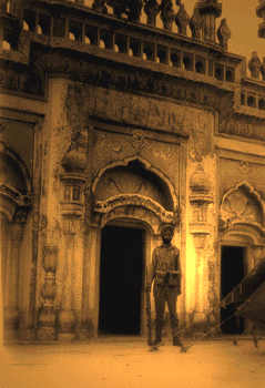 [Image: Indian soldier standing guard outside a mosque at Shakargarh, Pakistan]